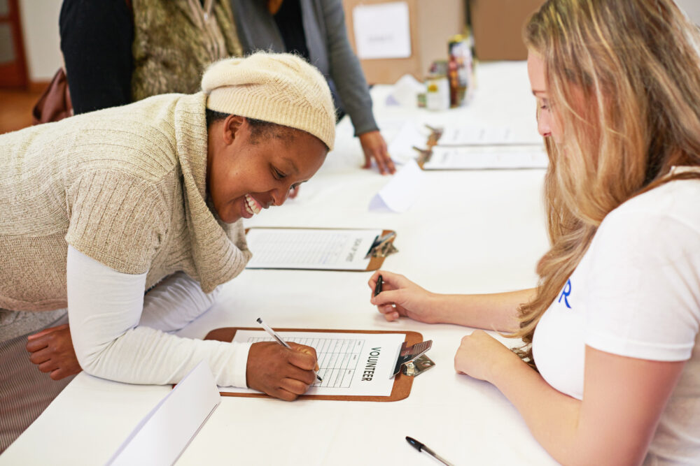 Women, sign up and clipboard for charity, volunteer or kindness at church for care with accountability. Group, checklist and donation to community for commitment, support or choice for call to action.